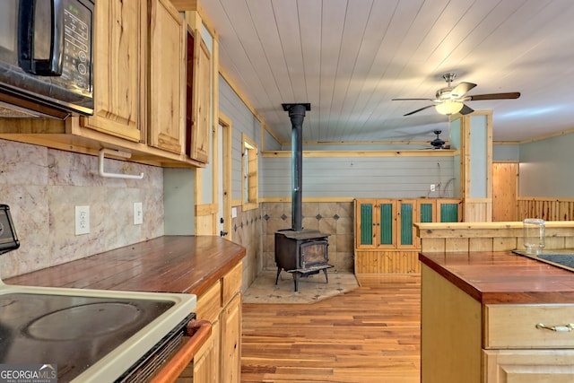 266 Ritchie Rd, Tiger, GA 30576 - kitchen with a wood stove, black microwave, butcher block countertops, electric range oven, and light wood finished floors