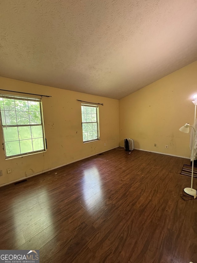 3739 Jamestown Ct, Doraville, GA 30340 - empty room with dark wood finished floors, a textured ceiling, baseboards, and lofted ceiling