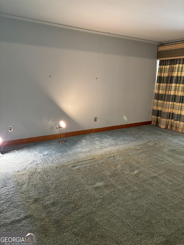 unfurnished room with baseboards, ornamental molding, and carpet flooring