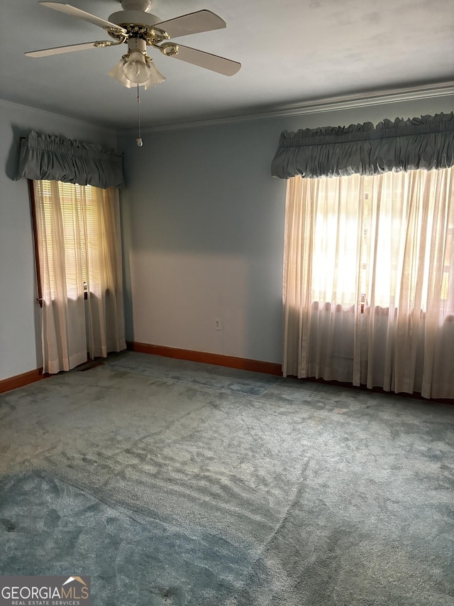 unfurnished room featuring ceiling fan, crown molding, carpet flooring, and baseboards