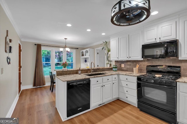 kitchen featuring white cabinets, a sink, a peninsula, tasteful backsplash, and black appliances