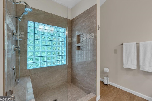 bathroom with a walk in shower, baseboards, and wood finished floors