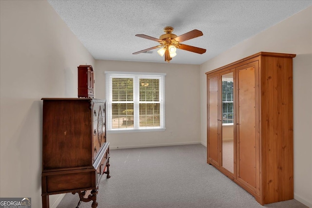 unfurnished room featuring baseboards, ceiling fan, and a textured ceiling
