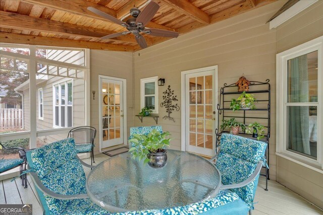 sunroom / solarium with beamed ceiling, outdoor dining area, and ceiling fan
