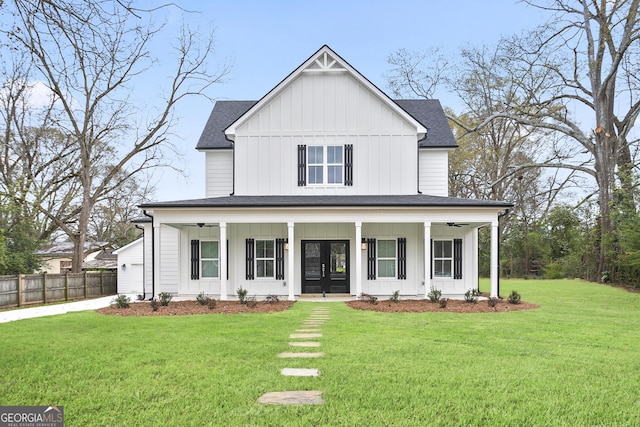 modern farmhouse featuring a porch, a shingled roof, board and batten siding, and fence