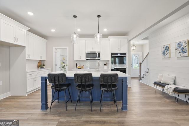 kitchen featuring tasteful backsplash, stainless steel appliances, light countertops, and white cabinets