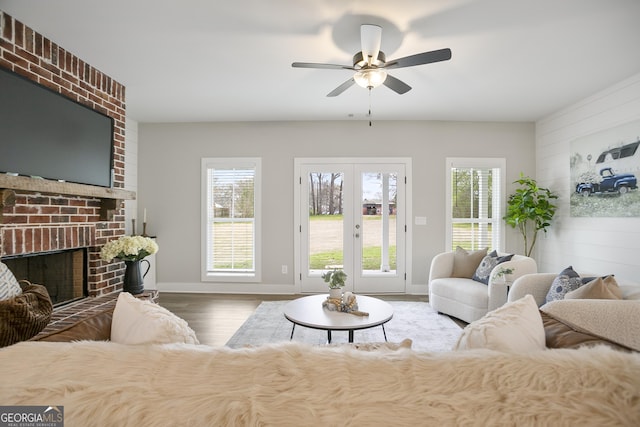 living room featuring baseboards, wood finished floors, a wealth of natural light, and ceiling fan