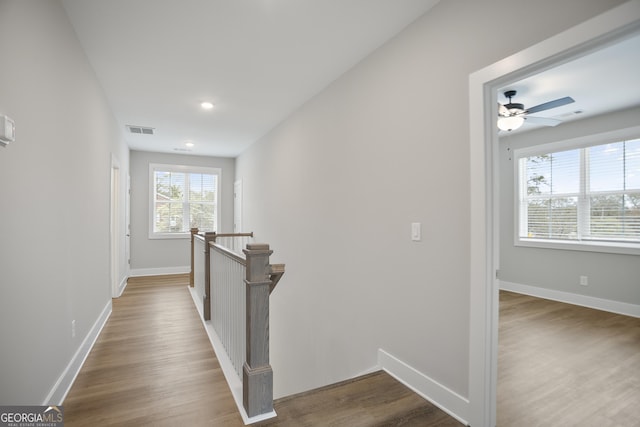 hallway featuring recessed lighting, wood finished floors, an upstairs landing, baseboards, and visible vents