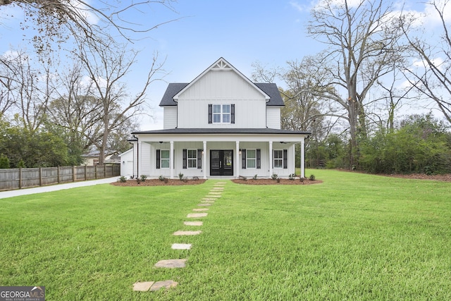 modern farmhouse with covered porch, fence, a front lawn, and concrete driveway