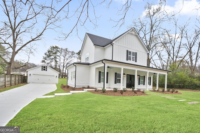 modern farmhouse style home featuring an outbuilding, a detached garage, a ceiling fan, board and batten siding, and fence