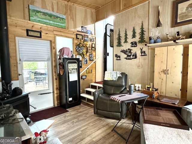 interior space featuring a wood stove, wood walls, and wood finished floors