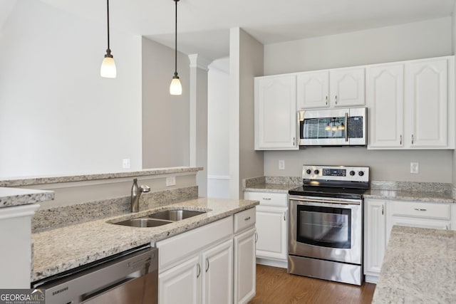 kitchen with stainless steel appliances, a sink, white cabinets, and light stone countertops