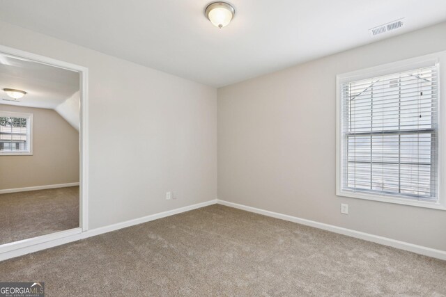 carpeted spare room featuring baseboards