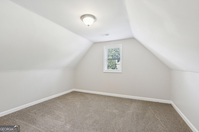 additional living space featuring carpet, lofted ceiling, and baseboards