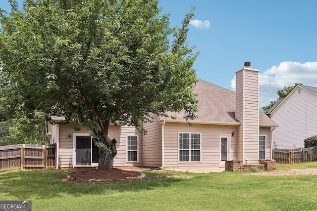 back of property with a chimney and a shingled roof