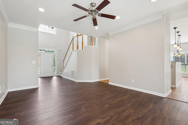 unfurnished living room featuring healthy amount of natural light, dark wood-style flooring, ornamental molding, and recessed lighting