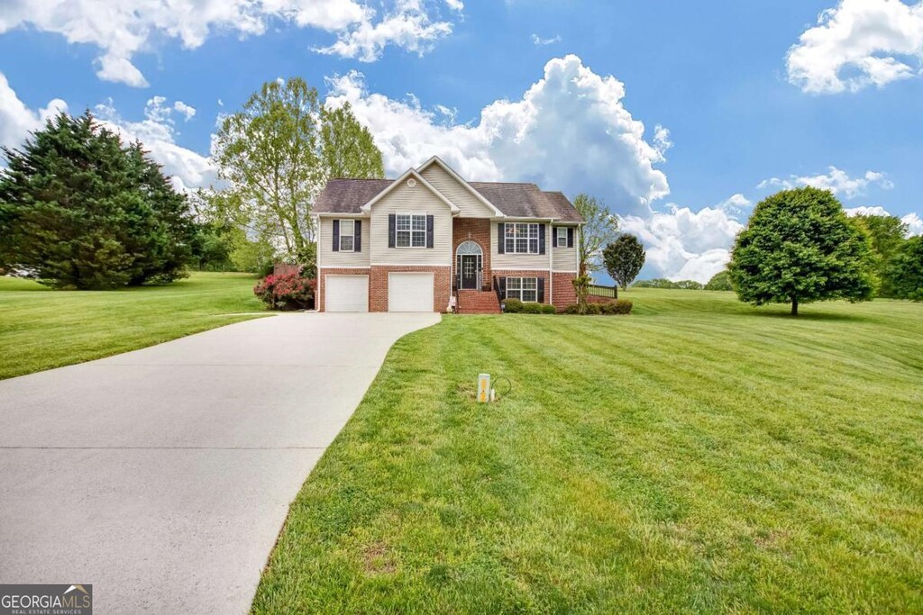236 Five Oaks Dr, Clarkesville, GA 30523 - raised ranch with concrete driveway, a front lawn, an attached garage, and brick siding