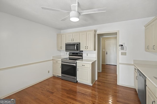 kitchen with appliances with stainless steel finishes, dark wood-style flooring, ceiling fan, and light countertops