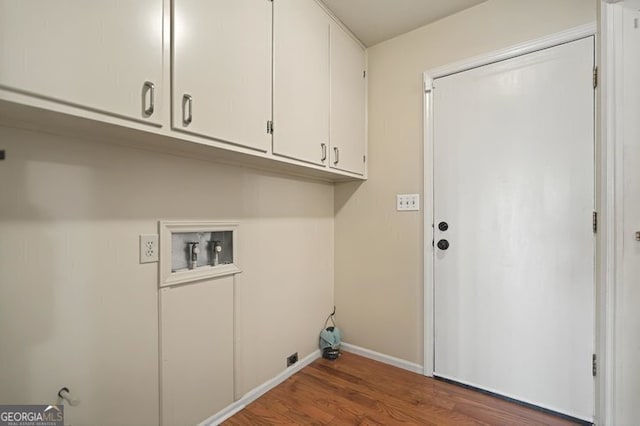 clothes washing area with hookup for a washing machine, wood finished floors, cabinet space, and baseboards