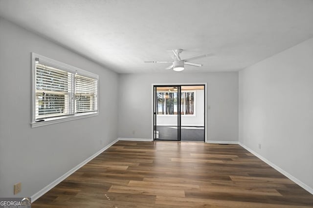 unfurnished room featuring baseboards, wood finished floors, and ceiling fan