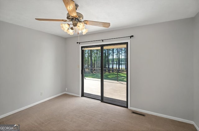 empty room with baseboards, visible vents, ceiling fan, and carpet flooring