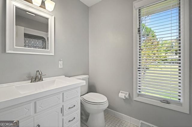 full bath with toilet, vanity, tile patterned floors, and baseboards