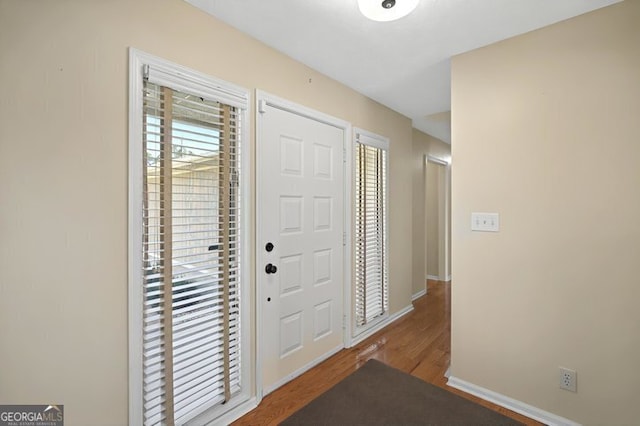entryway with baseboards and wood finished floors