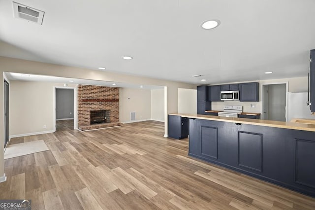 kitchen with light wood-style floors, white appliances, visible vents, light countertops, and open floor plan