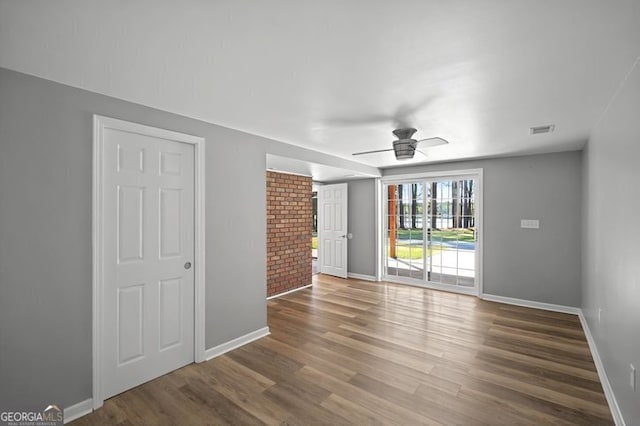 unfurnished living room with baseboards, visible vents, wood finished floors, and ceiling fan