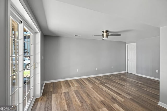 unfurnished room with visible vents, ceiling fan, baseboards, and dark wood-type flooring