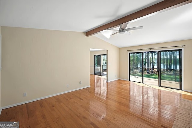 spare room featuring wood finished floors, lofted ceiling with beams, a ceiling fan, and baseboards