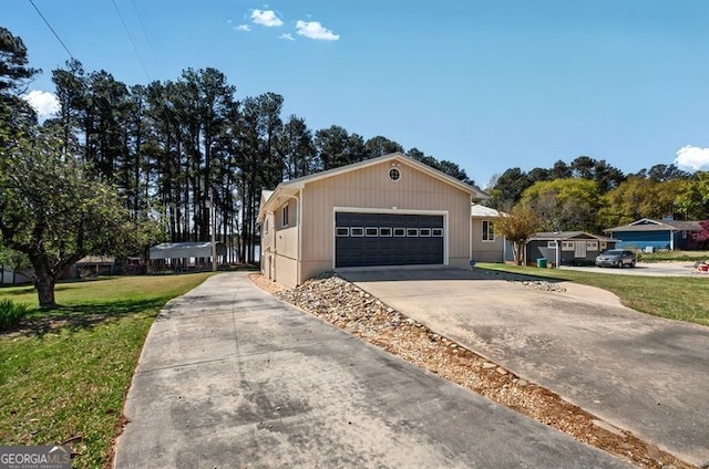 view of side of home with driveway, an attached garage, and a lawn