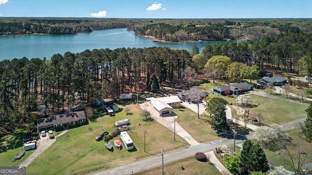 bird's eye view featuring a wooded view and a water view