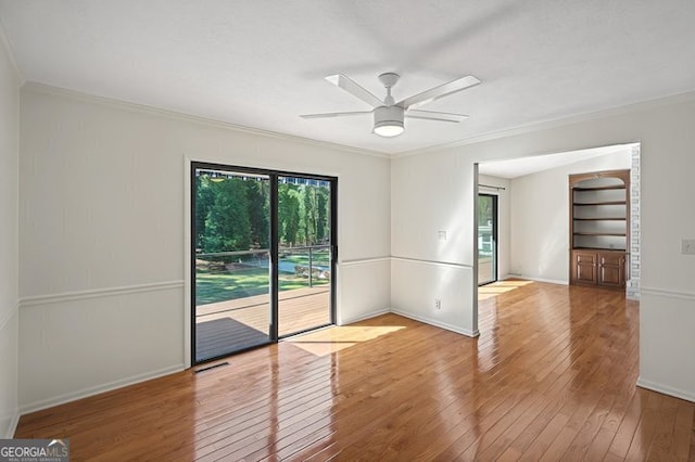 unfurnished room featuring hardwood / wood-style floors, a ceiling fan, ornamental molding, and a healthy amount of sunlight