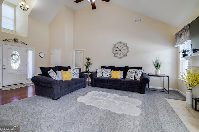 living room with visible vents, a wealth of natural light, carpet, and high vaulted ceiling