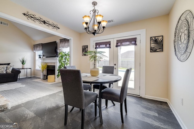 dining space featuring a notable chandelier, a tile fireplace, visible vents, and french doors