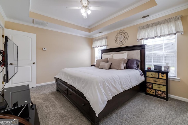 carpeted bedroom featuring baseboards, visible vents, a raised ceiling, and ornamental molding