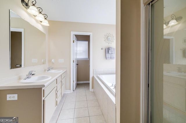 bathroom featuring a garden tub, tile patterned flooring, a sink, and double vanity
