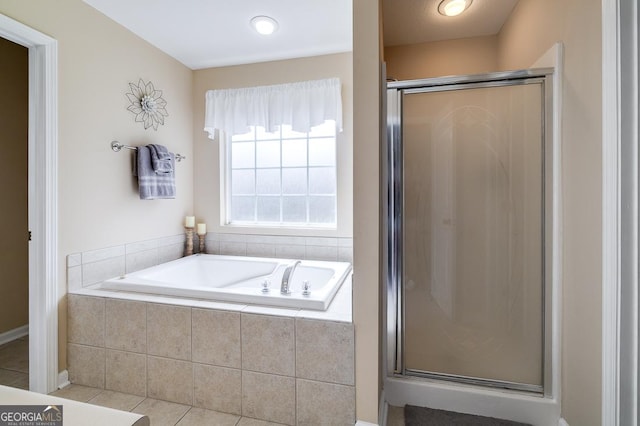 full bathroom featuring a stall shower, a bath, and tile patterned floors
