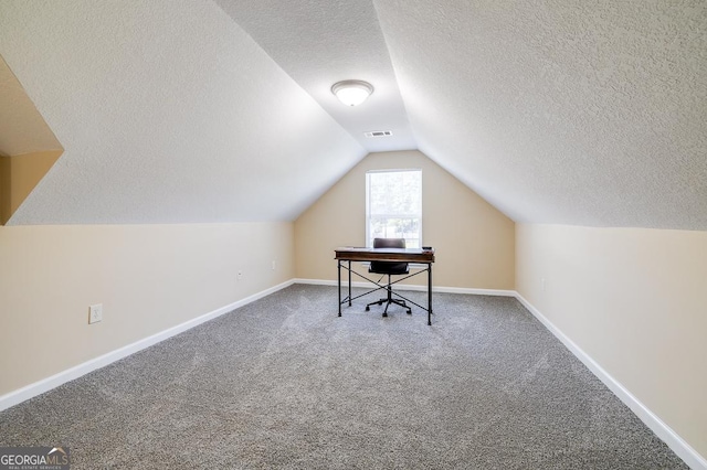 office area featuring lofted ceiling, visible vents, carpet floors, and a textured ceiling