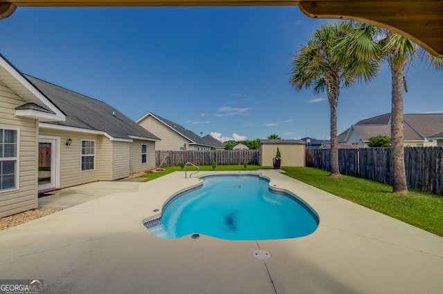 view of pool with a fenced in pool, a patio area, an outbuilding, a lawn, and a fenced backyard
