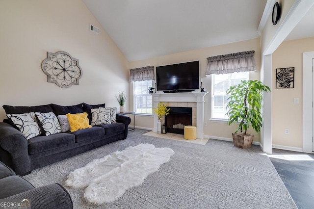 carpeted living room with a tile fireplace, visible vents, high vaulted ceiling, and baseboards