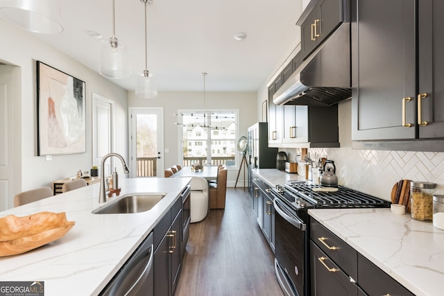 kitchen featuring range with gas stovetop, stainless steel dishwasher, a sink, under cabinet range hood, and dark wood-style flooring