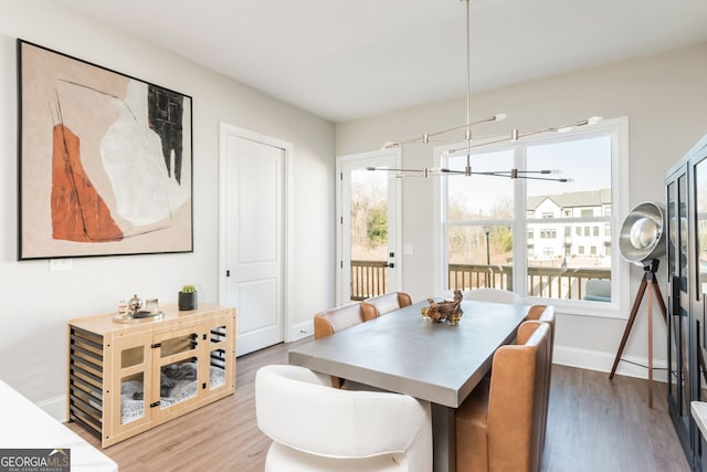 dining area with a notable chandelier, wood finished floors, and baseboards