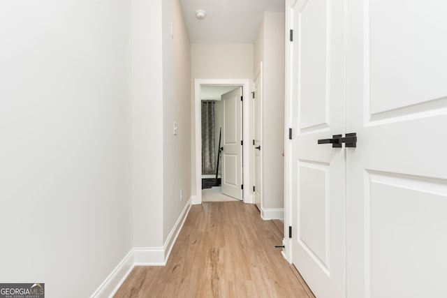 hallway with baseboards and light wood-type flooring