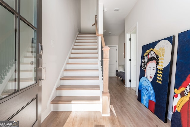 stairs with wood finished floors and baseboards