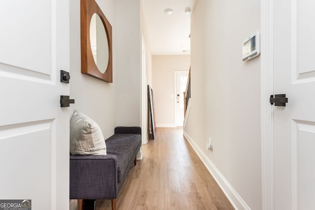hall featuring light wood finished floors and baseboards