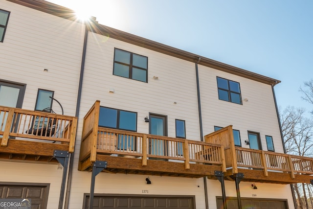 back of property with a garage and a balcony