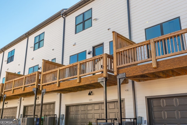 rear view of house with central AC, a balcony, and a garage