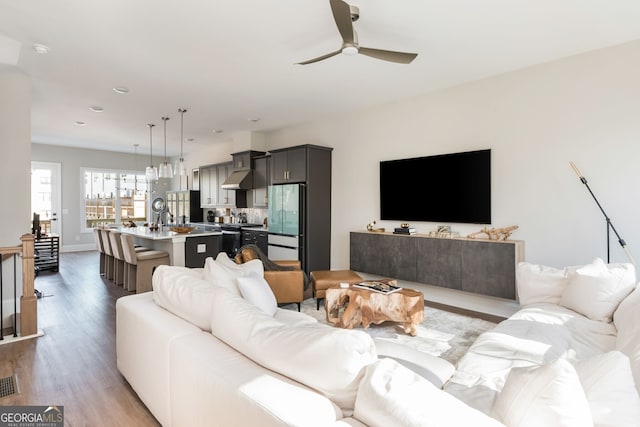 living area featuring recessed lighting, wood finished floors, baseboards, visible vents, and a ceiling fan